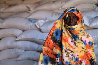 A Sudanese woman stand besides humanitarian aid WFP photo